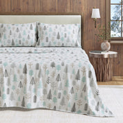Bed with tree-patterned bedding in a bedroom setting