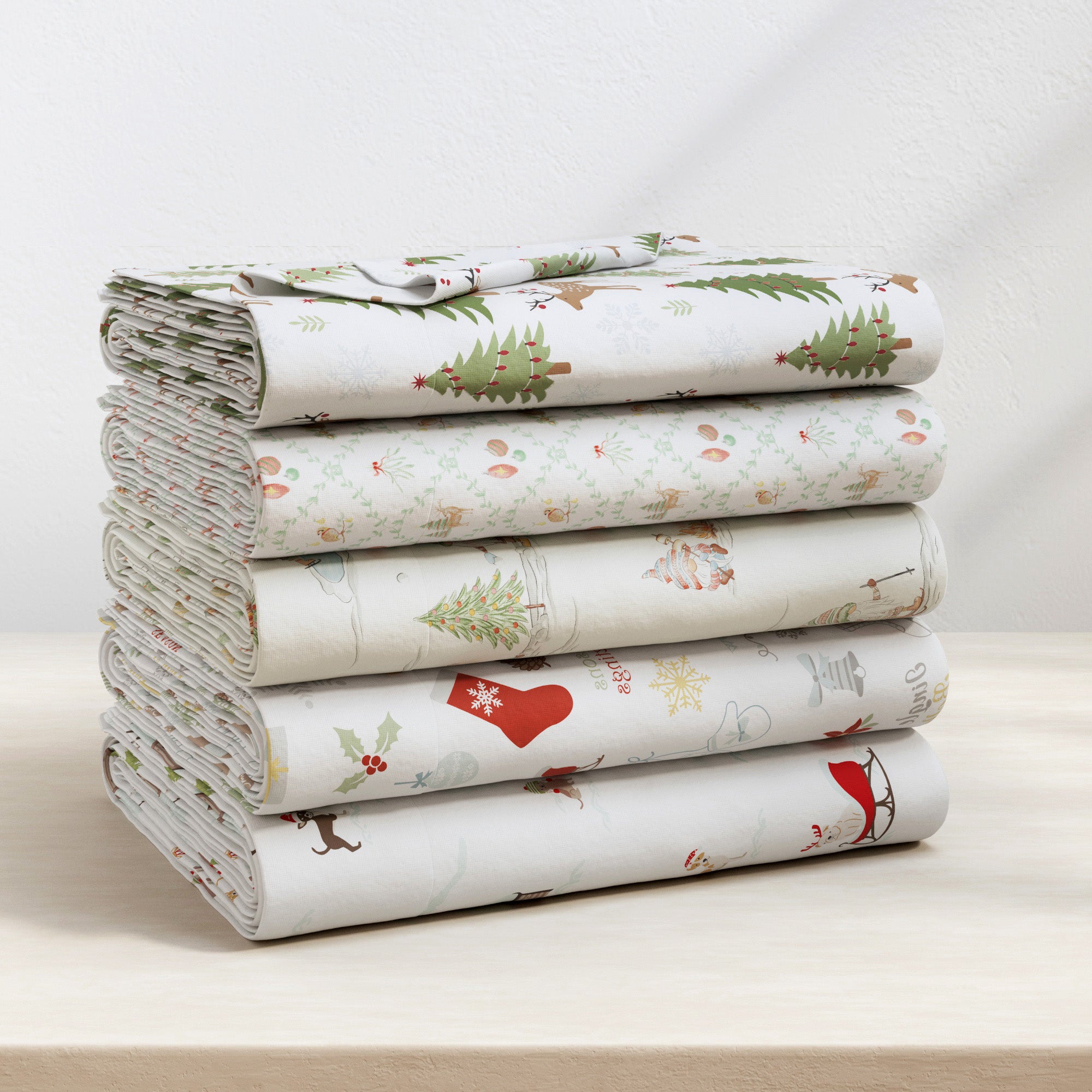 Stack of folded fabric with Christmas-themed patterns on a light surface.