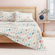 Bed with colorful tree-patterned bedding in a bedroom setting.